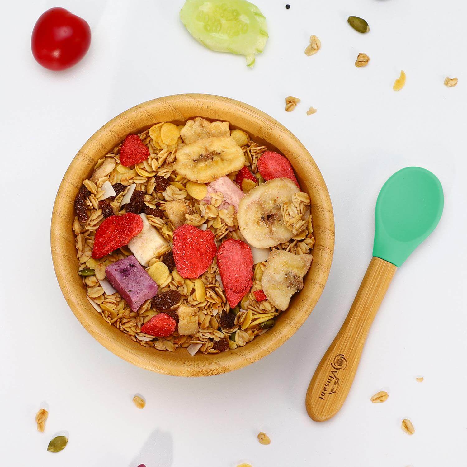 Vinsani bamboo bowl and spoon set filled with colorful granola, featuring a yellow silicone base for kids' mealtimes.