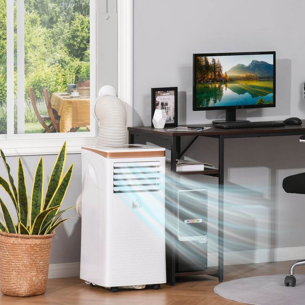 Portable air conditioner cooling a home office with a computer and a window view, promoting comfort and airflow.