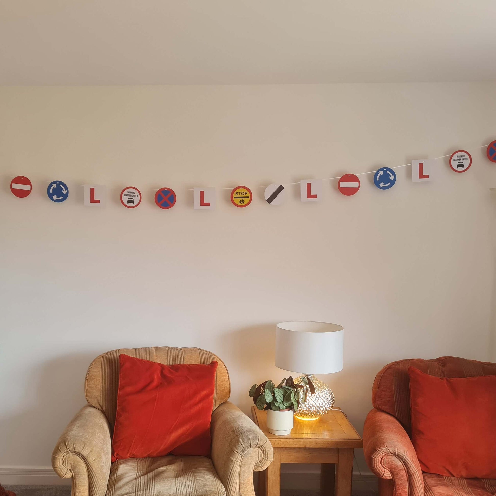 Learner Driver party bunting with L plates and road signs displayed in a living room setting.