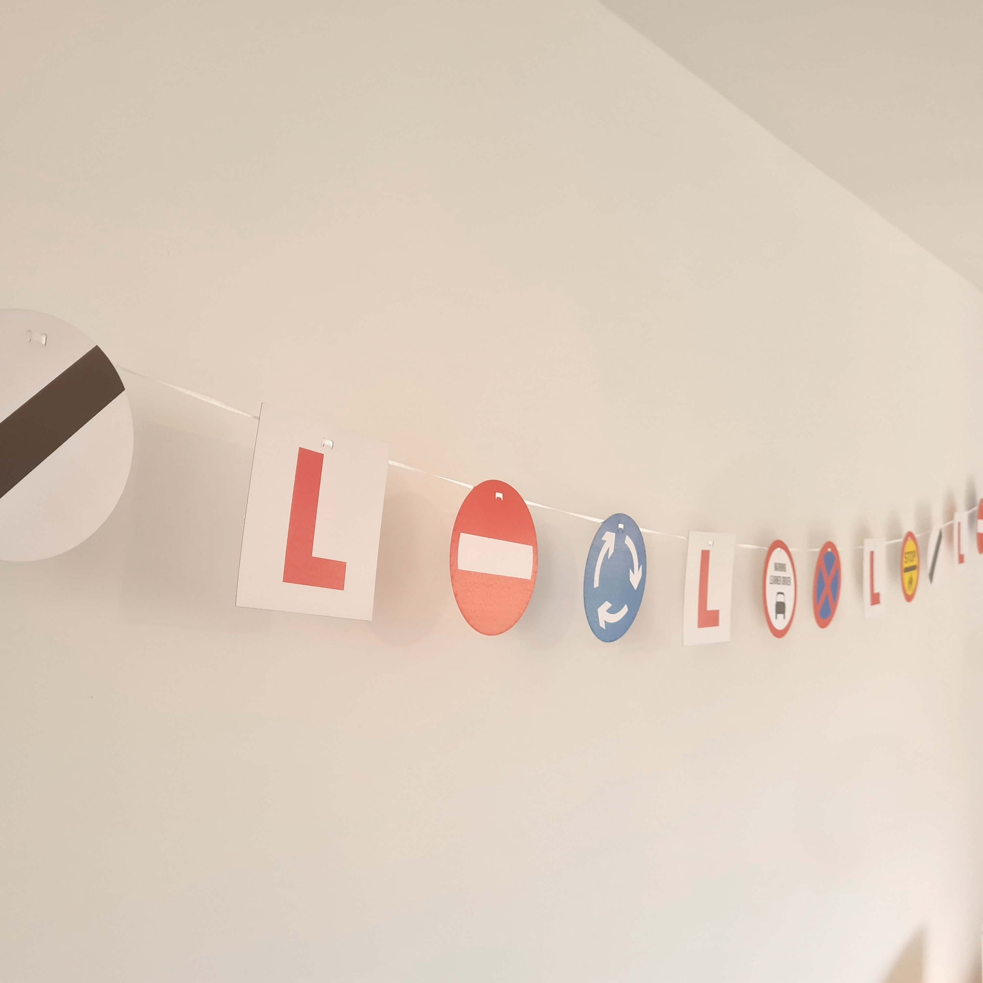 Colorful learner driver bunting with L plates and UK road signs for a fun party decoration.
