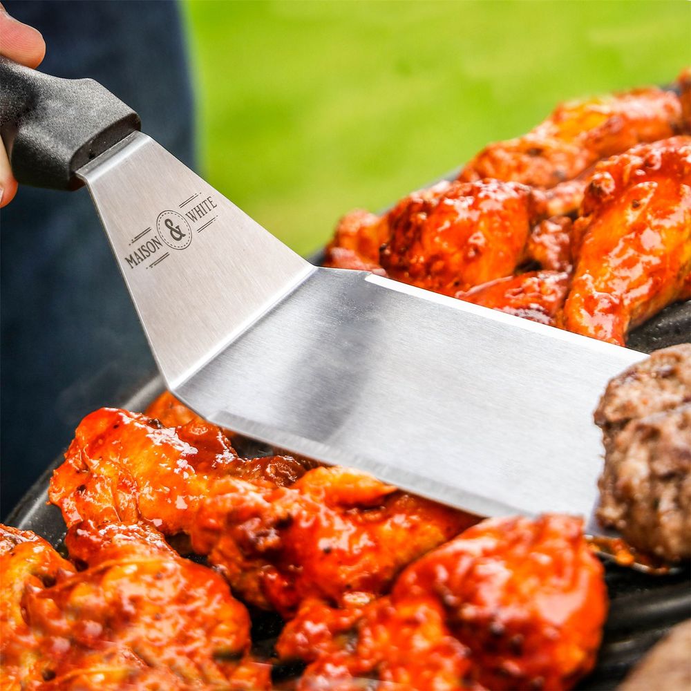 Stainless Steel Spatula In Use Flipping Burger On BBQ